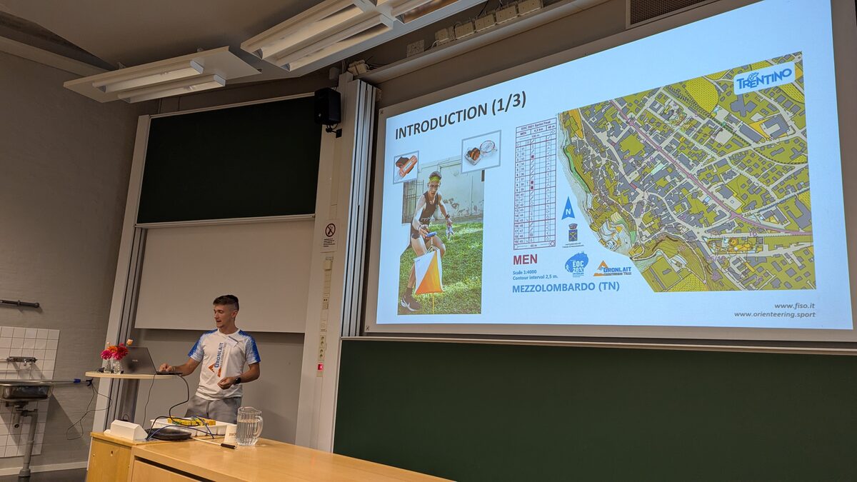 A speaker presenting an orienteering performance analysis with maps